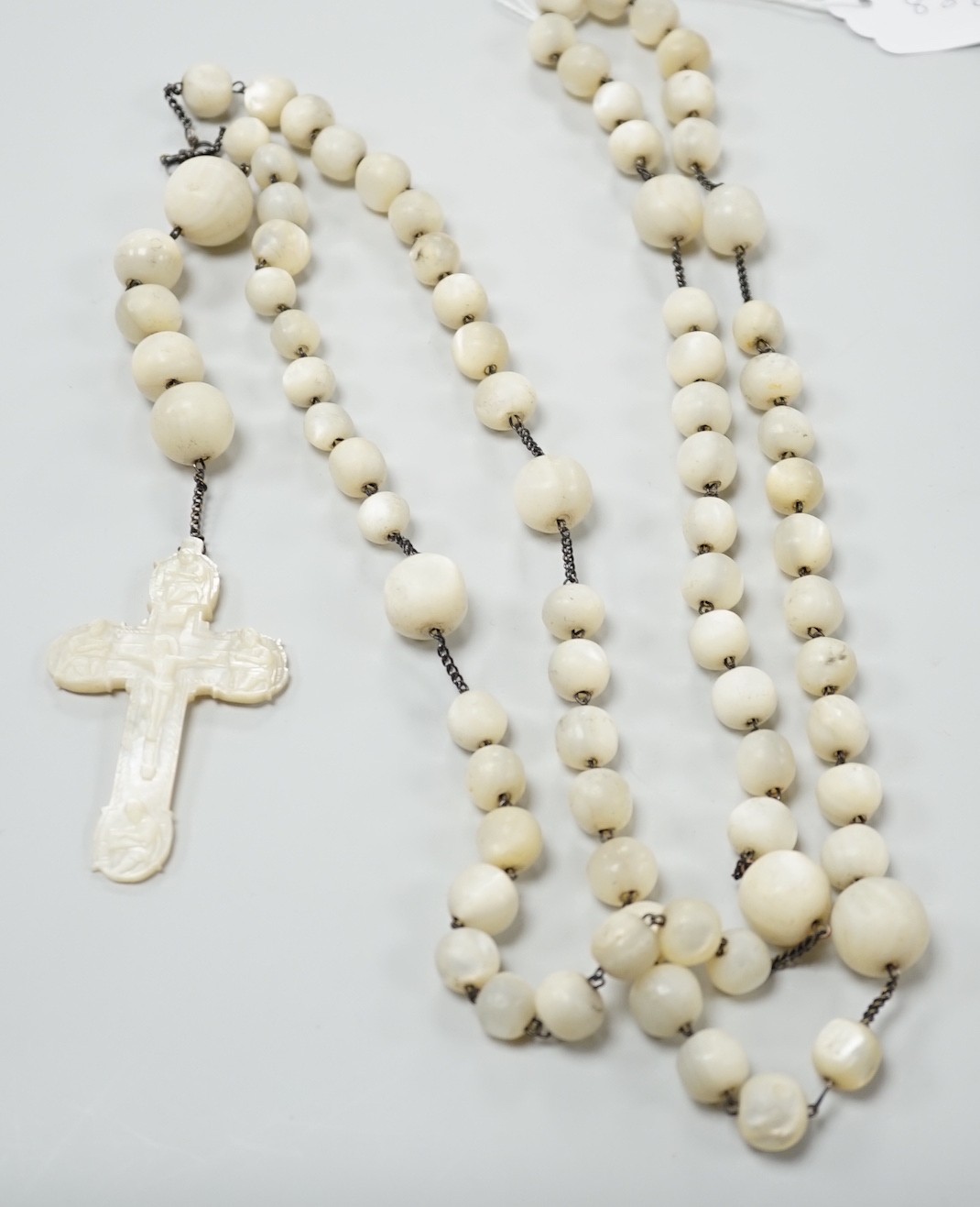 A long mother of pearl rosary, 158cm, with carved mother of pearl crucifix pendant, 8cm.